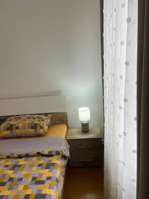 a bedroom with a bed and a table with a lamp at Apartman Flora in Novi Grad
