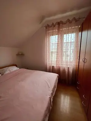 a bedroom with a large bed and a window at Apartman Flora in Novi Grad