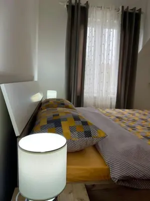 a bedroom with a bed and a table and a chair at Apartman Flora in Novi Grad
