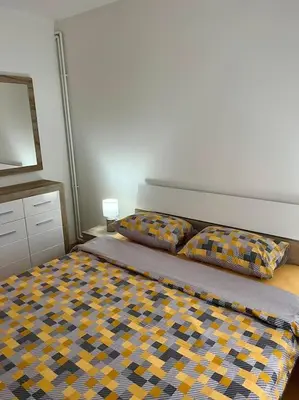 a bedroom with a bed and a dresser and a television at Apartman Flora in Novi Grad