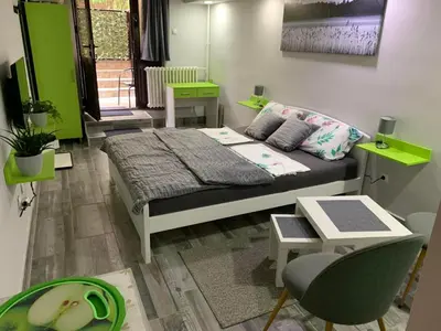 a bedroom with a bed and a table and a chair at Apartman Lara in Belgrade