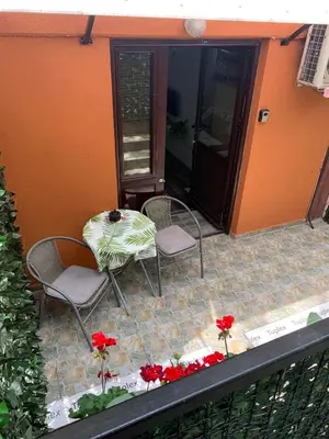 a patio with a table and chairs and flowers at Apartman Lara in Belgrade