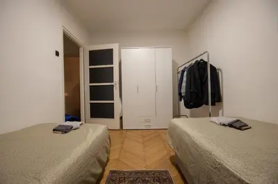 a bedroom with two beds and a door with a closet at St Marks in Belgrade