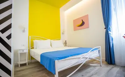 a bedroom with a bed with a blue and yellow wall at Studio Pop Art in Batajnica