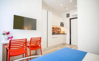 a room with two chairs and a table and a tv at Studio Pop Art in Batajnica