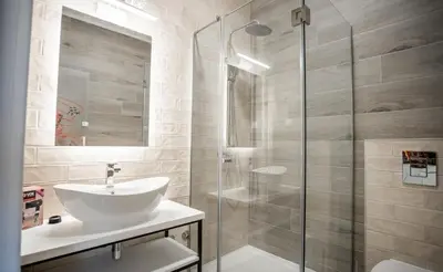 a bathroom with a sink and a glass shower at Studio Pop Art in Batajnica