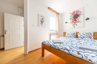 a bedroom with a bed with a blue and white comforter at Marshall Residence in Belgrade