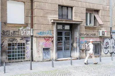 a man walking in front of a building with graffiti at Marshall Residence in Belgrade