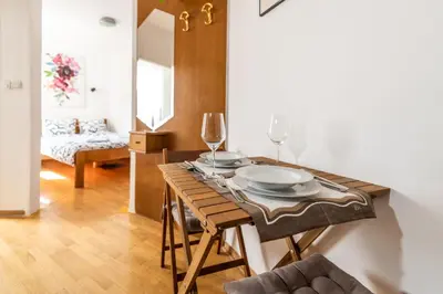 a dining room with a table with plates and wine glasses at Marshall Residence in Belgrade
