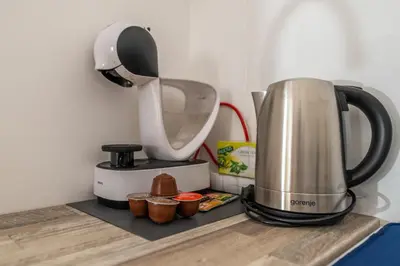 a coffee maker on a counter next to cupcakes at Marshall Residence in Belgrade