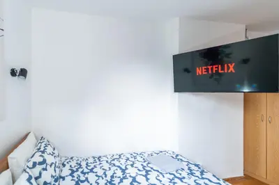 a bedroom with a bed and a tv on the wall at Marshall Residence in Belgrade