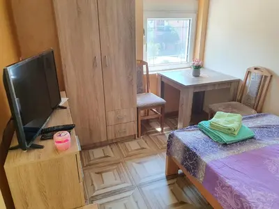 a room with a tv and a bed and a table at Small cute doublebed room A4 in Pančevo in Pančevo