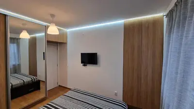 a bedroom with a mirror and a bed and a tv at Porodicno-poslovni udoban stan in Vračar (historical)