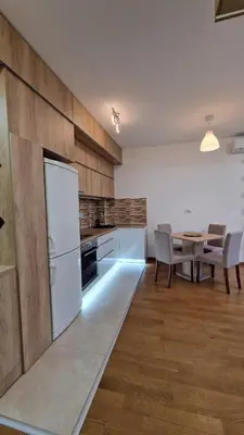 a kitchen with a table and a white refrigerator at Porodicno-poslovni udoban stan in Vračar (historical)