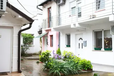 a courtyard of a house with purple flowers at Red Kruz in Vračar (historical)