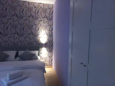 a bedroom with a bed with lights on the wall at Apartman Central Place in Belgrade
