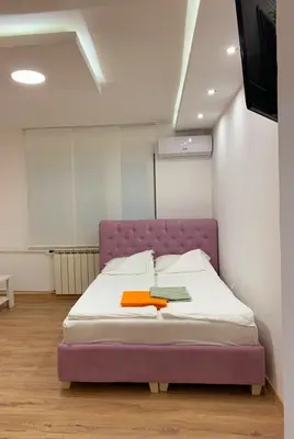 a bedroom with a purple bed in a room at LUX BANOVO BRDO apartman in Belgrade