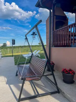 a swinging chair sitting on a porch with a yard at Villa Sladjana in Mladenovac