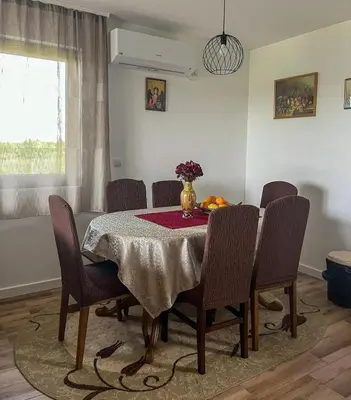 a dining room table with chairs and a vase of flowers on it at Villa Sladjana in Mladenovac