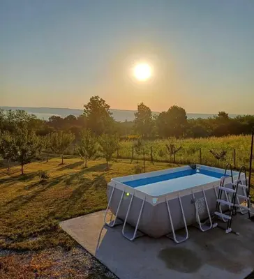 a swimming pool with the sunset in the background at Villa Sladjana in Mladenovac