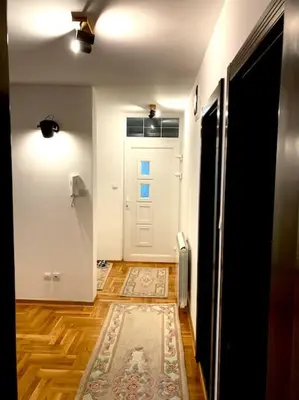a hallway with a white door and a rug on the floor at AmazingMemories3 in Belgrade