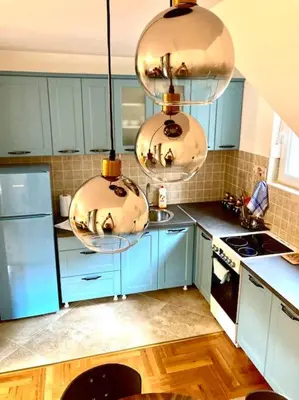 a kitchen with blue cabinets and two hanging pots at AmazingMemories3 in Belgrade