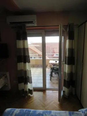 a bedroom with a sliding glass door to a balcony at Apartments Bella Mare Belgrade in Belgrade