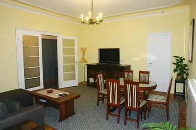 a living room with a table and chairs and a television at Apartment Tašmajdan in Belgrade
