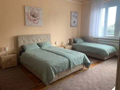 a bedroom with a bed and a couch and a window at Apartment Tašmajdan in Belgrade
