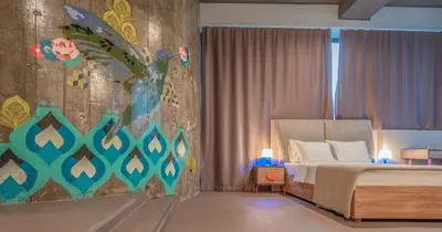 a bedroom with a bed and a painting on the wall at Avangarda Suites in Belgrade