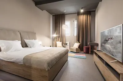 a bedroom with a bed and a flat screen tv at Avangarda Suites in Belgrade