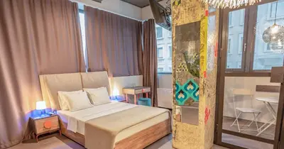 a small bedroom with a bed and a table at Avangarda Suites in Belgrade