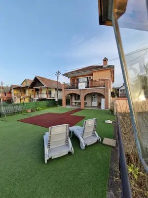 a yard with two lawn chairs and a house at Vila Soleil in Smederevo