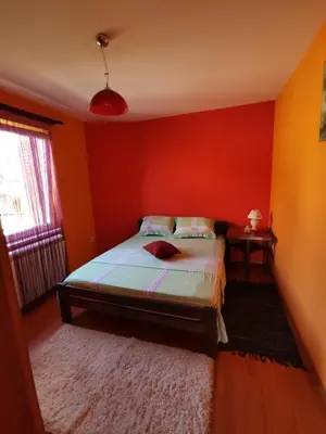 a bedroom with orange walls and a bed with a rug at Vila Soleil in Smederevo