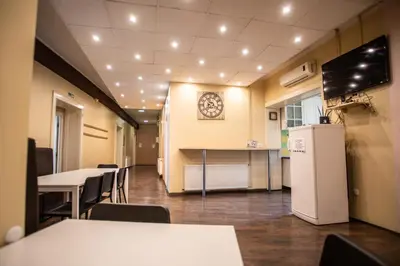 a conference room with tables and chairs and a refrigerator at All in Hostel in Belgrade