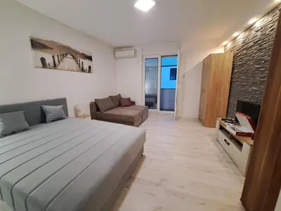 a bedroom with a large bed and a couch at Apartment BeoSun in Belgrade