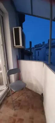a chair sitting on a balcony next to a window at Apartment BeoSun in Belgrade
