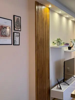 a wooden partition in a room with a television at Apartman Marija in Zvezdara