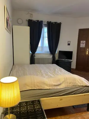 a bedroom with a bed and a lamp and a window at Studio Vracar in Belgrade