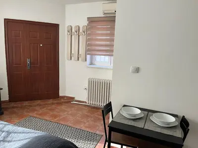 a bedroom with a table and a door at Studio Vracar in Belgrade