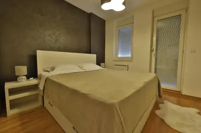 a bedroom with a large bed and a window at A blok - One bedroom apartment in Belgrade