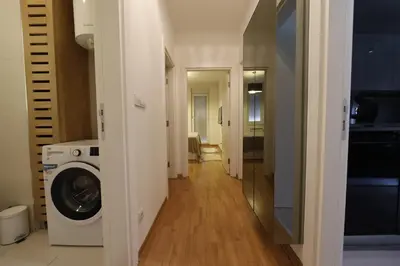 a hallway with a washer and dryer in a apartment at A blok - One bedroom apartment in Belgrade