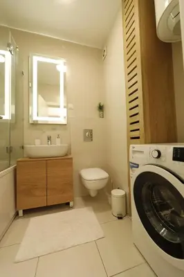 a bathroom with a sink and a washing machine at A blok - One bedroom apartment in Belgrade