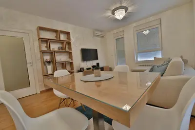 a dining room and living room with a table and chairs at A blok - One bedroom apartment in Belgrade