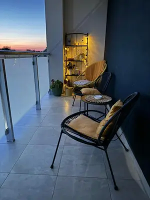two chairs and a table on a balcony at JR Lux apartman in Stara Pazova