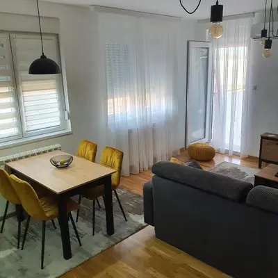 a living room with a table and a couch at JR Lux apartman in Stara Pazova