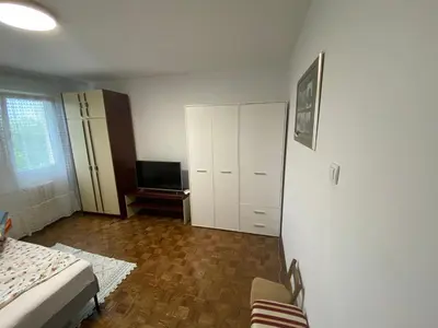a bedroom with a bed and a cabinet and a television at Novi Beograd Dr.Agostina Neta in Novi Beograd