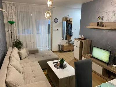 a living room with a couch and a tv at Apartman Popović in Ruma