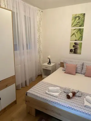 a bedroom with a bed and a mirror at Apartman Popović in Ruma
