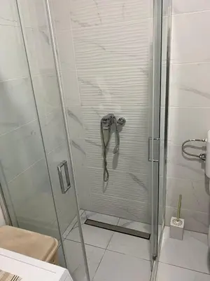 a shower in a bathroom with a glass door at Apartman Popović in Ruma